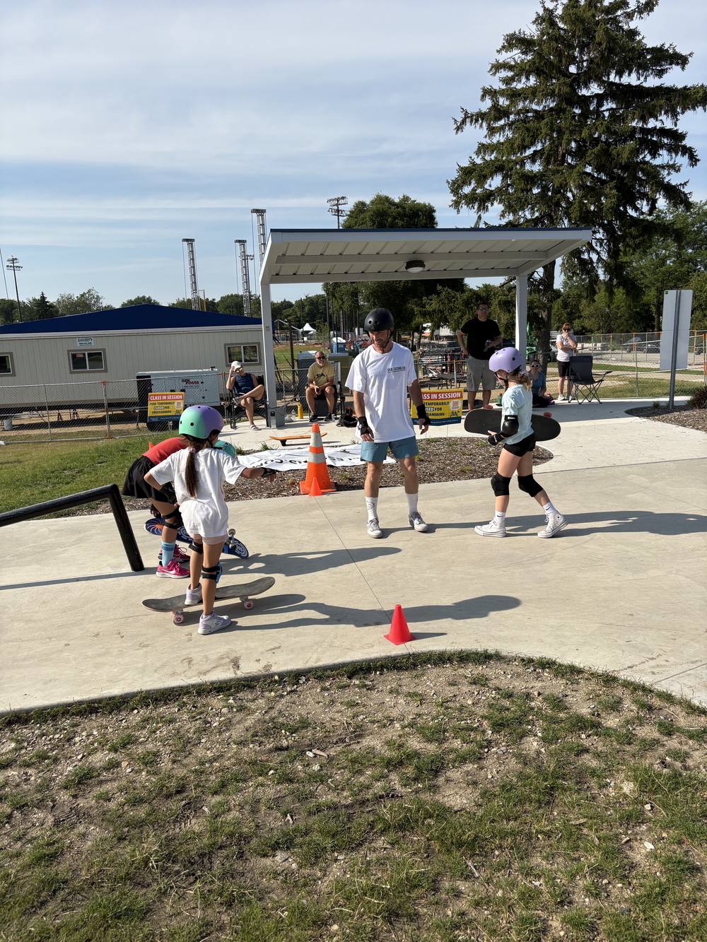 A coach guiding young skaters through cone drills at Recreation Park skate park in Arlington Heights