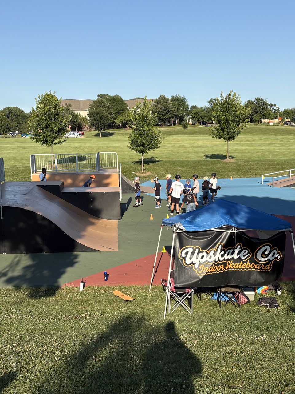 A group of young skaters gathered near the ramps during a Skate Lessons Chicago class at Newton Park in Glen Ellyn
