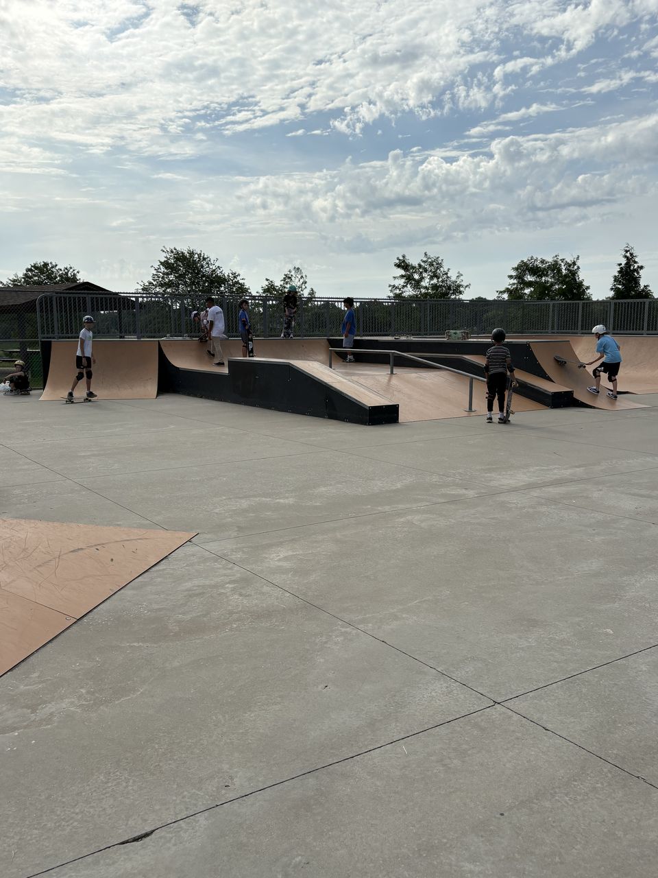 Young skaters with their skateboards along the railing at Palatine Prairie Skatepark
