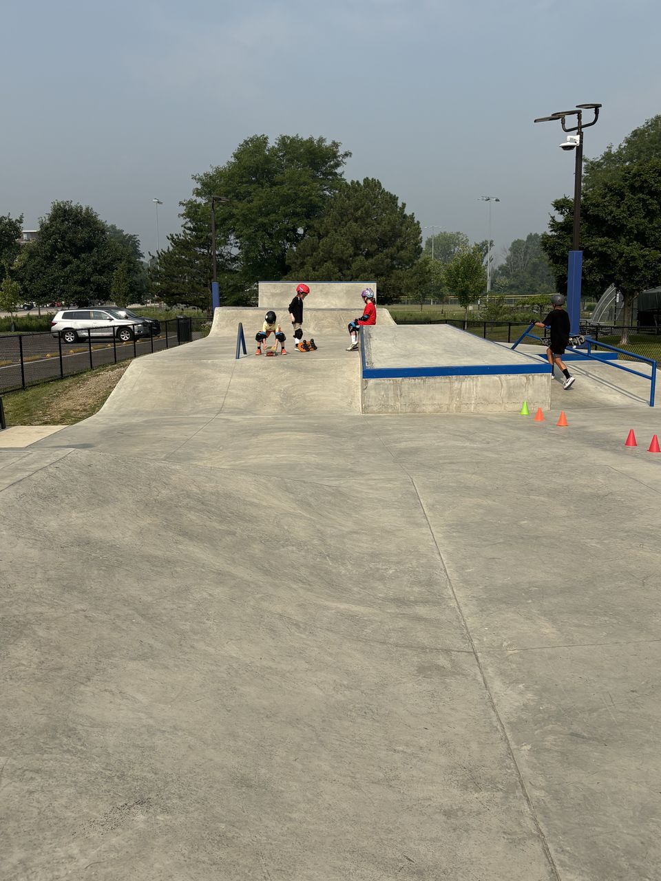 Skate Lessons Chicago students with their skateboards on the ramps at All Wheels Park in Westmont